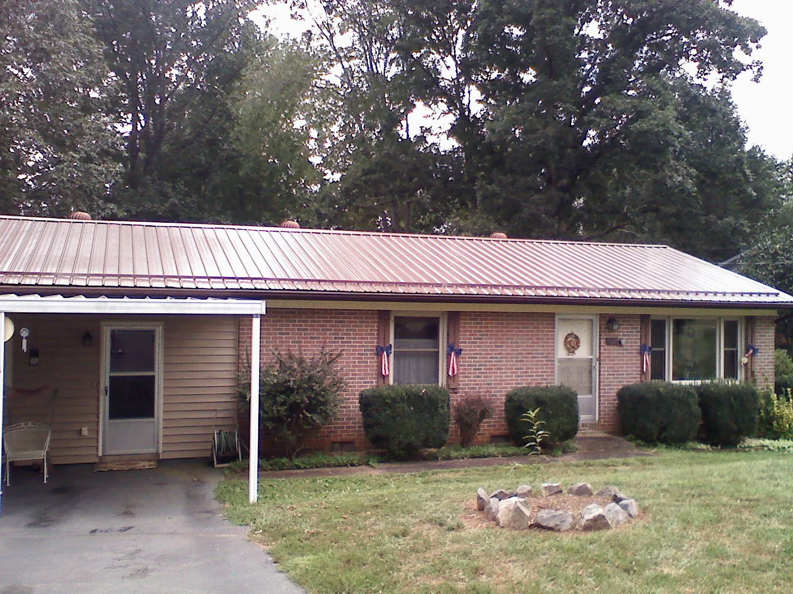 Bronze metal roof and carport on a brick ranch home — Roof Repair work by our crew in Brookfield